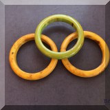 J140. 3 Bakelite bangles. Two beige colored and one green.